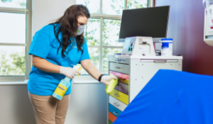 cleaning expert disinfecting a cabinet in a hospital